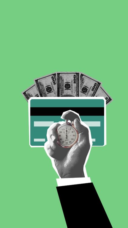 A hand holding a stopwatch over banknotes and a card