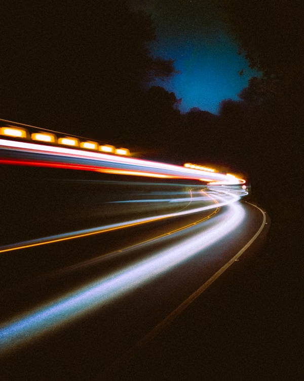 Light trails streaking along a night road